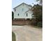 Side view of the home showing light blue siding, brick foundation, and lush backyard landscaping at 3200 Farmington, Vinings, GA 30339