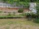 Beautiful backyard featuring retaining walls, various plants, trees and flowers, and two outdoor chairs at 3775 Pine Village Pl, Loganville, GA 30052