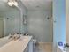 Bathroom with double sinks, a large mirror, and soft blue walls, featuring a tub at 3775 Pine Village Pl, Loganville, GA 30052
