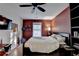 Bedroom with ceiling fan, red accent wall and a view to the fenced backyard at 3775 Pine Village Pl, Loganville, GA 30052