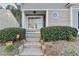 Inviting home entrance with well-manicured hedges and potted plants leading to the front door at 3775 Pine Village Pl, Loganville, GA 30052