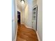 Hallway featuring wood floors, neutral walls and a decorative cabinet at 3775 Pine Village Pl, Loganville, GA 30052