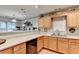 Well-lit kitchen with wooden cabinets, a sink, and a pass-through to another room at 3775 Pine Village Pl, Loganville, GA 30052
