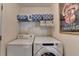 Well-equipped laundry room featuring modern washer and dryer, shelving, and decor at 3775 Pine Village Pl, Loganville, GA 30052