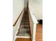 Carpeted staircase with hardwood flooring leading to the upper level of the home at 3775 Pine Village Pl, Loganville, GA 30052