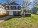 Charming two-story home features an attached garage, a well-manicured lawn and a yellow front door at 4665 Garden Hills Dr, Stone Mountain, GA 30083