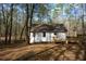 Backyard view of the house, framed by tall trees with a small deck at 98 Brenda Cir, Rockmart, GA 30153