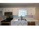 Bright kitchen featuring white cabinets, stainless steel appliances, and a stainless steel sink at 98 Brenda Cir, Rockmart, GA 30153