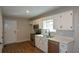 Functional kitchen with white cabinets, stainless steel appliances, and laminate flooring at 98 Brenda Cir, Rockmart, GA 30153