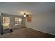Bright living room featuring a ceiling fan, neutral paint, and a large window with blinds at 98 Brenda Cir, Rockmart, GA 30153