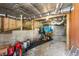 Unfinished basement area with exposed wood beams, concrete supports, and storage for various items at 2655 Lakeside Trl, Cumming, GA 30041