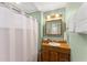 Well-lit bathroom featuring a shower with curtain, a wood vanity and a mirror at 2655 Lakeside Trl, Cumming, GA 30041