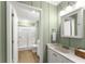 Neat bathroom featuring a shower, single sink vanity, and light-green paneled walls at 2655 Lakeside Trl, Cumming, GA 30041