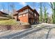 Exterior view of a rustic cabin-style home with natural wood siding and a terraced yard at 2655 Lakeside Trl, Cumming, GA 30041