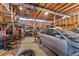 Cluttered garage interior with a partially disassembled car and various auto parts and tools scattered throughout at 2655 Lakeside Trl, Cumming, GA 30041