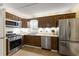 Traditional kitchen features wooden cabinets, stainless steel appliances, and a double sink below the window at 2655 Lakeside Trl, Cumming, GA 30041