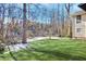 Spacious backyard with lush green lawn bordered by trees and partial views of nearby houses at 6828 Lockridge Dr, Atlanta, GA 30360