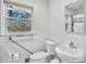 Clean bathroom featuring a grab bar, toilet and sink near the window at 6828 Lockridge Dr, Atlanta, GA 30360