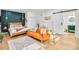 Open concept bedroom with a full kitchen, orange couch, and hardwood floors at 6828 Lockridge Dr, Atlanta, GA 30360