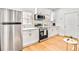 Contemporary kitchen featuring stainless steel appliances, white cabinets, and stylish gold hardware at 6828 Lockridge Dr, Atlanta, GA 30360