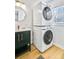 Efficient laundry space with stacked washer and dryer unit and green modern vanity at 6828 Lockridge Dr, Atlanta, GA 30360