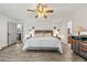 Bright bedroom featuring a ceiling fan, wood floors, and a view of the ensuite bathroom at 812 Bonnie Glen Se Dr, Marietta, GA 30067