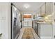 Bright kitchen featuring granite countertops, stainless steel appliances, and laundry in a closet at 812 Bonnie Glen Se Dr, Marietta, GA 30067