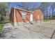 Rear view of brick home for sale featuring a concrete patio, minimal landscaping, and white trim at 1883 Clarke Ln, Decatur, GA 30035