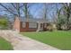 This brick home features a driveway and a well-manicured lawn at 1883 Clarke Ln, Decatur, GA 30035