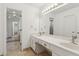 Bright bathroom with double sink vanity, large mirror, and tiled floors, plus view into adjacent rooms at 3923 Ashford Lake Ne Ct, Brookhaven, GA 30319