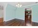 A bright dining room featuring a modern chandelier, lovely aqua walls, and hardwood flooring at 3923 Ashford Lake Ne Ct, Brookhaven, GA 30319