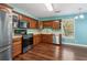 Kitchen with stainless steel appliances, wood cabinetry, and hardwood floors at 3923 Ashford Lake Ne Ct, Brookhaven, GA 30319