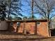 Brick home's back exterior showcases a door, windows, and yard with a storage shed at 877 Verona Dr, Clarkston, GA 30021