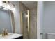 Modern bathroom featuring a glass enclosed shower with gold hardware, vanity, and decorative mirror at 877 Verona Dr, Clarkston, GA 30021