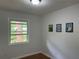 Well-lit bedroom featuring hardwood floors, fresh paint, and brightened by natural light from the window at 877 Verona Dr, Clarkston, GA 30021