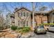 View of tan and brick condominium featuring a balcony and parked car near green bushes at 102 Barrington Hills Dr, Atlanta, GA 30350