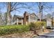Charming condo exterior with a stone wall, and greenery; also featuring a balcony and chimney at 102 Barrington Hills Dr, Atlanta, GA 30350
