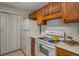 Kitchen features white appliances and wood cabinets, offering functionality at 102 Barrington Hills Dr, Atlanta, GA 30350