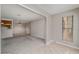 Open concept condo living room, showing gray carpet and open views to dining and kitchen at 102 Barrington Hills Dr, Atlanta, GA 30350