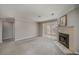 Cozy living room featuring gray carpet, fireplace, and white trim with a view into the kitchen at 102 Barrington Hills Dr, Atlanta, GA 30350