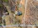 Aerial view of a quaint home on a private lot, surrounded by mature trees, walking trails, and a fire pit at 118 Raven Rd, Villa Rica, GA 30180