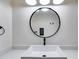 Stylish bathroom vanity with a modern vessel sink, framed round mirror, and contemporary lighting at 118 Raven Rd, Villa Rica, GA 30180