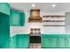 Bright kitchen with stainless steel range, custom hood, and teal cabinets at 118 Raven Rd, Villa Rica, GA 30180