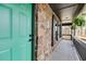 Close-up of the porch featuring stone accents, a hanging fern, and a turquoise front door at 118 Raven Rd, Villa Rica, GA 30180