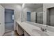 Bright bathroom with dual sink vanity, a large mirror, wood floors, and a shower at 1659 Hay Patch Ln, Loganville, GA 30052