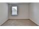 A vacant bedroom offers a window with blinds and neutral carpet at 1659 Hay Patch Ln, Loganville, GA 30052