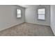 Comfortable bedroom with two bright windows, neutral walls, and plush carpeting at 1659 Hay Patch Ln, Loganville, GA 30052