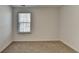 A sunny bedroom has a window with blinds, neutral carpet, and fresh white walls at 1659 Hay Patch Ln, Loganville, GA 30052