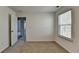 A bright bedroom has a window with blinds, neutral carpet, and fresh white walls at 1659 Hay Patch Ln, Loganville, GA 30052