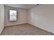 An empty bedroom featuring a window with blinds and neutral carpet at 1659 Hay Patch Ln, Loganville, GA 30052